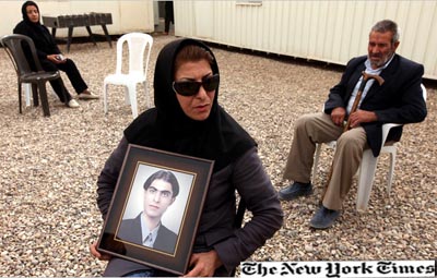 إيرانية تحمل صورة ابنها وهي في انتظار دخول معسكر أشرف، شمال شرقي بغداد، منذ 9 أيام لمقابلة أقاربها